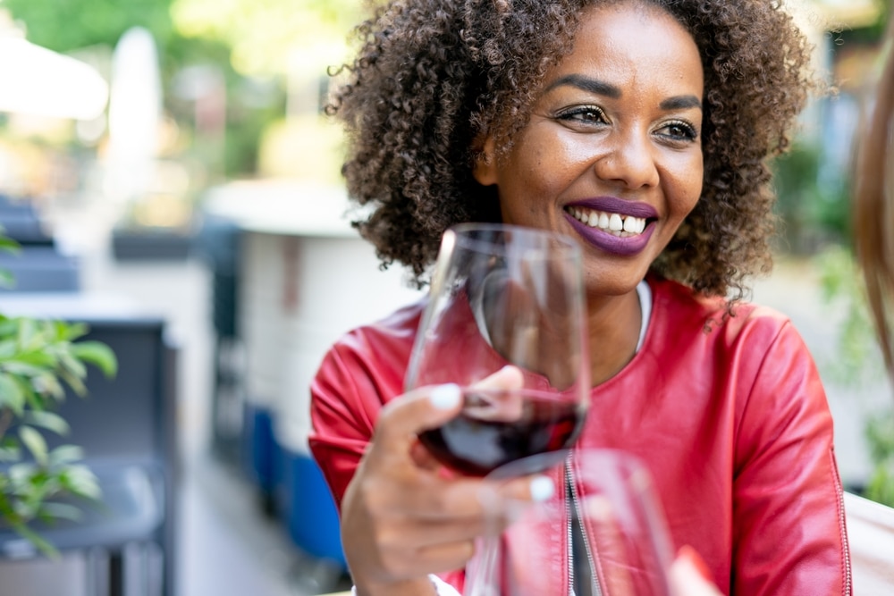 Black woman drinking wine outdoors at one of the best wineries in Virginia